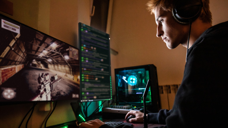 teenage-boy-playing-multiplayer-games-on-desktop-pc-in-his-dark-room-stock-photo